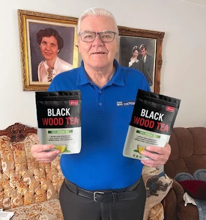Black Wood Tea customer holding two pouches of herbal tea